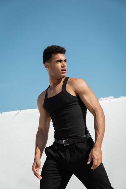 Portrét silného a stylového kubánského muže v módním černém oděvu hledícího do Miami, jižní pláž - Fotografie, Obrázek
