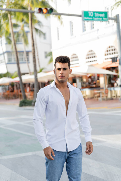 Retrato de un joven cubano en jeans y camisa blanca mirando a la cámara en Miami, playa sur - Foto, Imagen