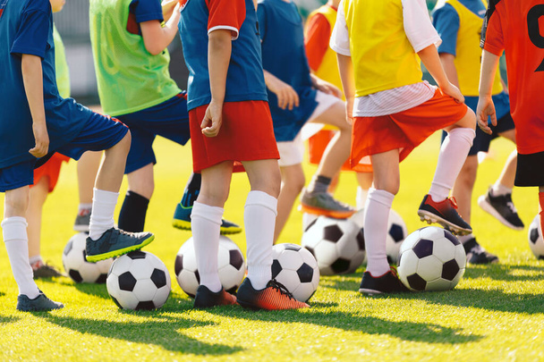 幼い子供のためのサッカートレーニング。トレーニングクラスでサッカーボールを持つ子供たちのグループ。夏の日にスポーツ練習を楽しんでいる男の子と女の子 - 写真・画像