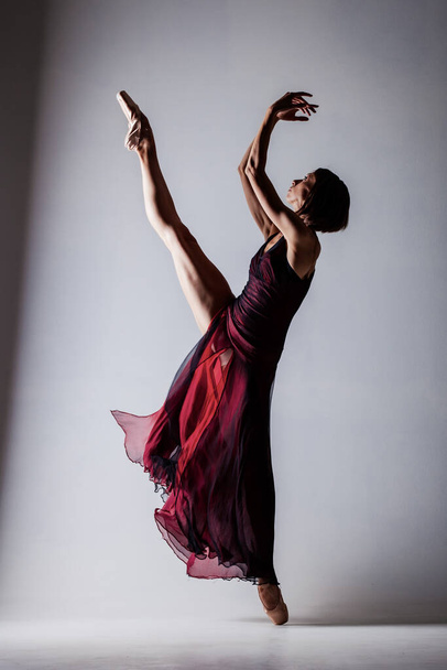 Half silhouette ballerina with a waving red dress. Elegant female ballet dancer. - Fotografie, Obrázek