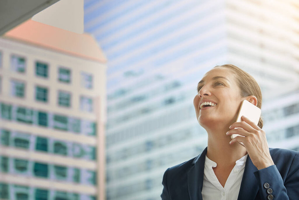 Sonriendo con éxito. una joven mujer de negocios hablando por su celular camino a la oficina - Foto, Imagen