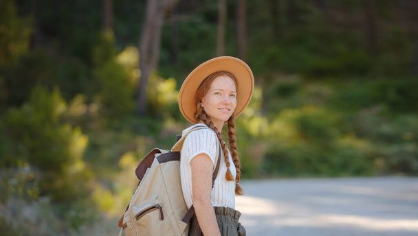 Kavkazský zázvor mladá krásná žena batohem cestování sám v lese. Atraktivní cestovatel rozhlédnout a prozkoumat, zatímco procházka v přírodě dřeva se štěstím a zábavou během dovolené výlet. - Fotografie, Obrázek