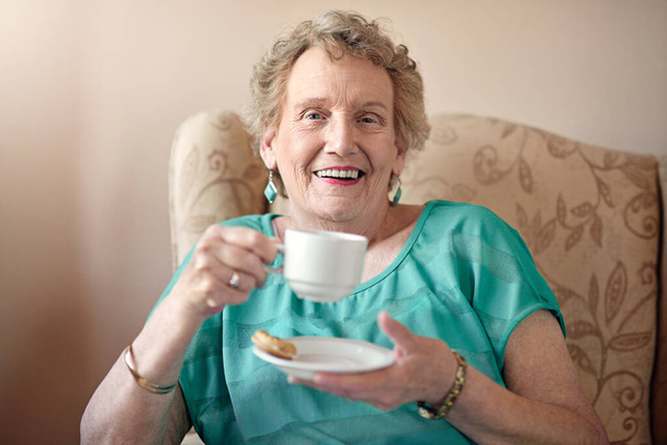 It takes a long time to get this sweet. a senior woman having a cup of coffee at home - Photo, Image