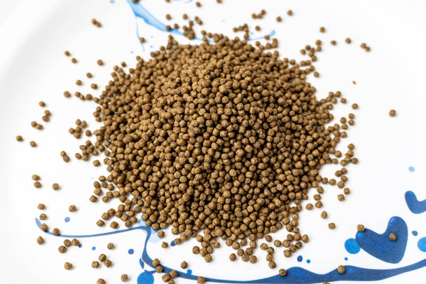 Animal feed for all kind of fish closeup with white background. The Feed for catfish at the end of the nursery stage and the beginning of the growing stage - Photo, Image
