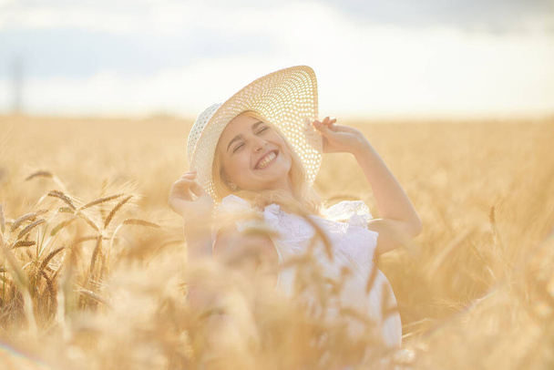Portrait of happy woman in hat, posing in wheat field  - Fotó, kép