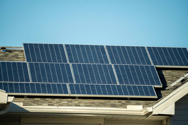 Vista aerea del tetto domestico americano regolare con pannelli fotovoltaici solari blu per la produzione di energia elettrica ecologica pulita. Elettricità rinnovabile a emissioni zero. - Foto, immagini