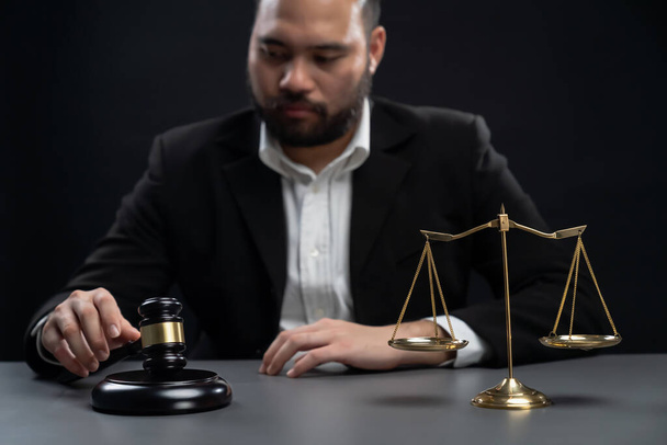 Focus symbols of justice, gavel hammer and scale balance on blurred background of thoughtful lawyer or judge sitting at his desk for integrity and fairness of the legal system. equility - Photo, Image