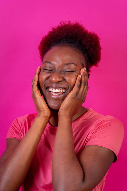 Young african american woman isolated on a pink background smiling and laughing, studio shoot - Φωτογραφία, εικόνα