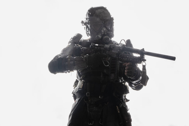 Shot of military man with rifle and gas mask against white background with backlit. - Photo, Image