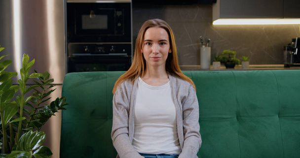Portrait of cheerful woman, looking at camera at kitchen. Beautiful teen girl posing at home. Beautiful lady relaxing on sofa, close up view face headshot portrait. - Φωτογραφία, εικόνα