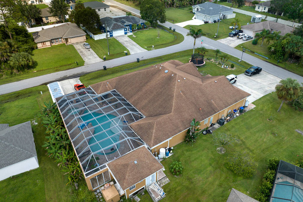 Vista aérea da típica casa privada contemporânea americana com recinto exterior lanai cobrindo grande piscina. Conceito de vida ao ar livre e se divertindo na água da piscina na Flórida sol de verão. - Foto, Imagem