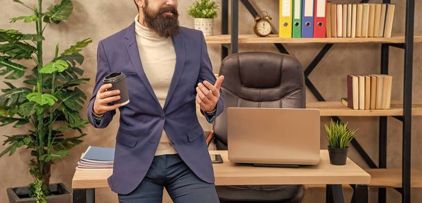 Hombre profesional vista de la cosecha celebración de té o taza de café sentado en el escritorio de la oficina, descanso. - Foto, Imagen