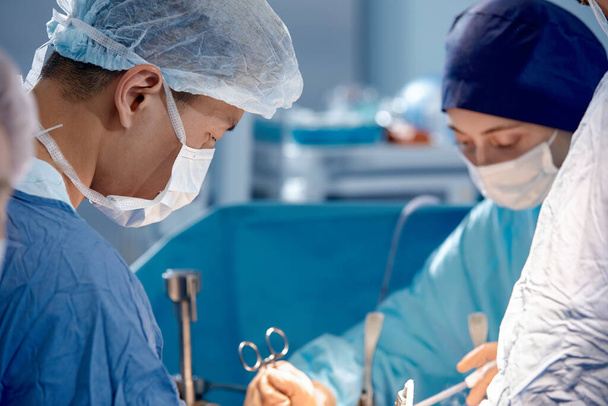 Faces of surgeons in the operating room during the operation, modern medicine, medical staff during a complex operation, medical science, close-up. - 写真・画像