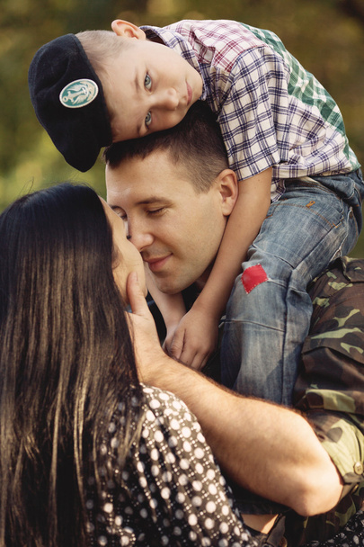 Жена и сын обнимают солдата
 - Фото, изображение