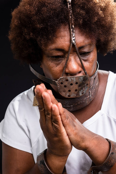Portrait du visage d'une femme noire avec un masque de fer sur le visage, représentant l'esclave Anastacia. Prier pour moins de douleur. Esclavage au Brésil. - Photo, image