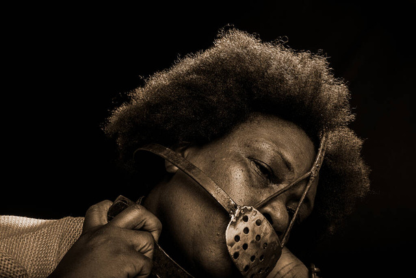Портрет черной женщины, заключенной в тюрьму с железной маской на лице, изображающей рабыню Анастасию. Рабство в Бразилии. - Фото, изображение