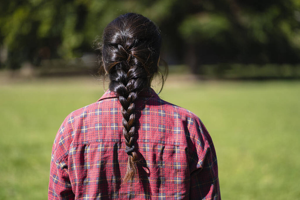 Latinská žena zezadu nosí cop v parku - Fotografie, Obrázek