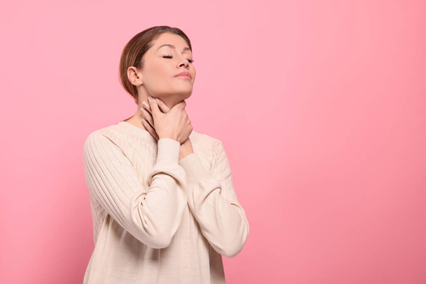 Woman suffering from sore throat on pink background. Space for text - Fotoğraf, Görsel