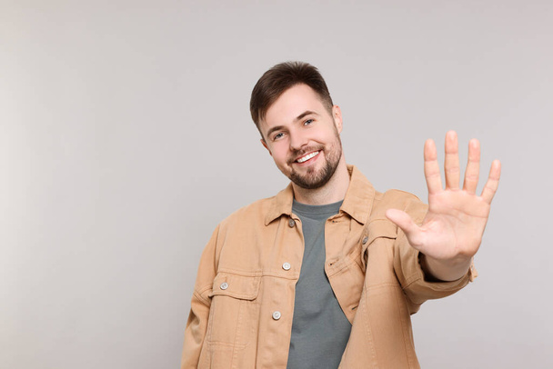 Man giving high five on grey background. Space for text - Fotoğraf, Görsel