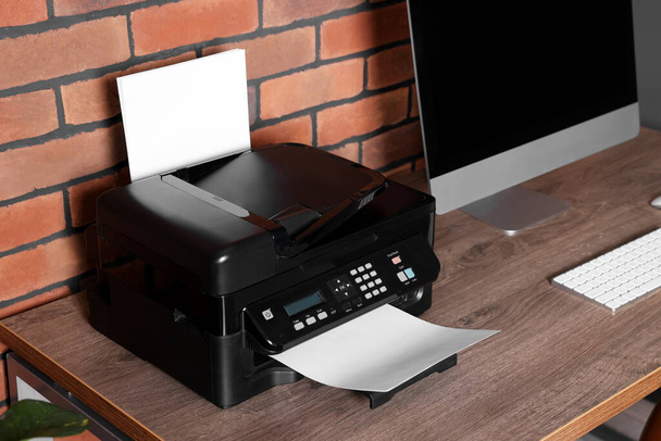 Modern printer with paper near computer on wooden desk at home - Fotoğraf, Görsel