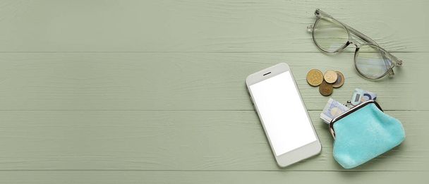 Monedero con dinero, gafas y teléfono móvil sobre fondo de madera verde con espacio para texto, vista superior - Foto, Imagen