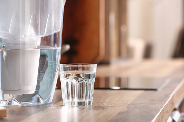 Filter jug and glass of water on kitchen counter, closeup - Photo, image
