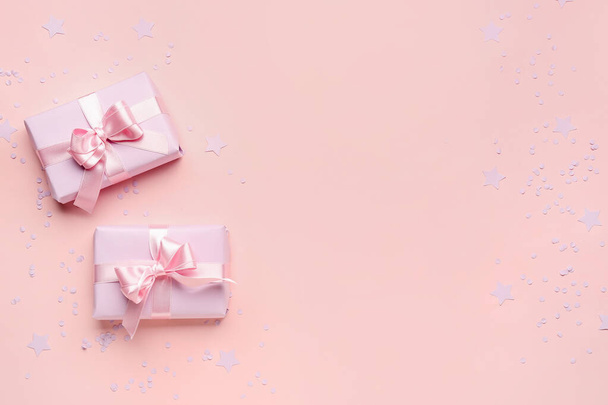 Cadeaudoosjes met mooie strikjes en confetti op roze achtergrond - Foto, afbeelding