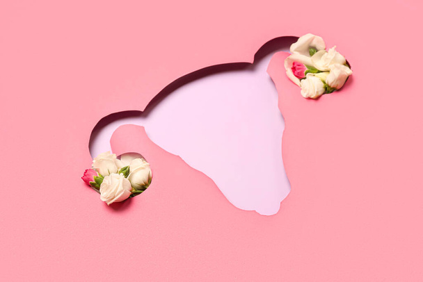 Carta rosa tagliata a forma di utero con rose su sfondo lilla - Foto, immagini