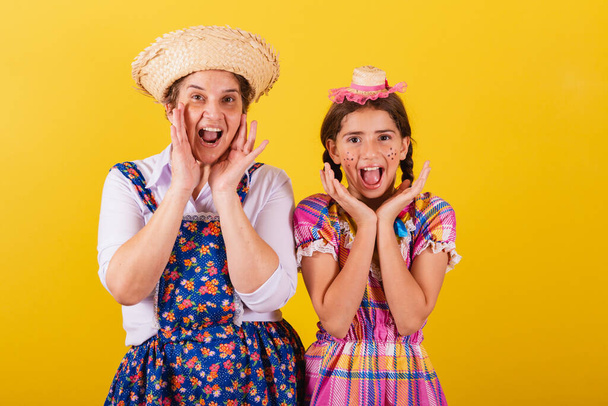 grandmother and granddaughter dressed in typical Festa Junina clothes. Wow, amazing, surprising, astonishment. - Photo, Image