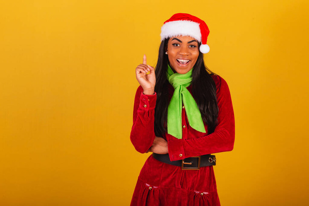 Beautiful black Brazilian woman, dressed in Christmas clothes, santa claus, thought idea. - Foto, afbeelding