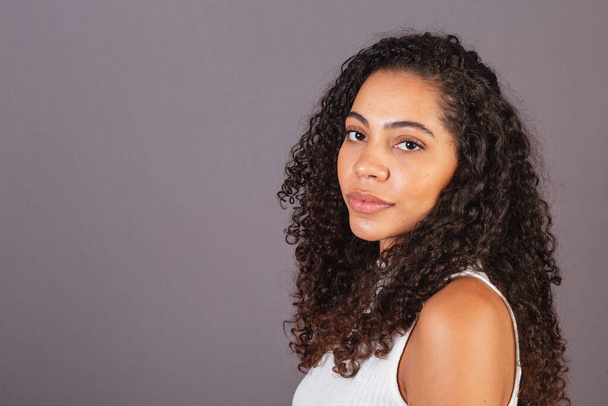 Young black Brazilian woman, side profile looking at camera. - Foto, Imagen