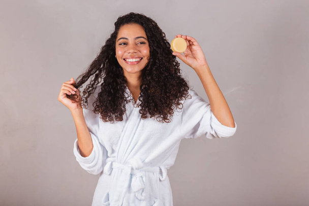 Brazilian black woman, wearing bathrobe and towel. vegan products for beauty and skin and hair care. soaps, Spa, self care. welfare. - Valokuva, kuva