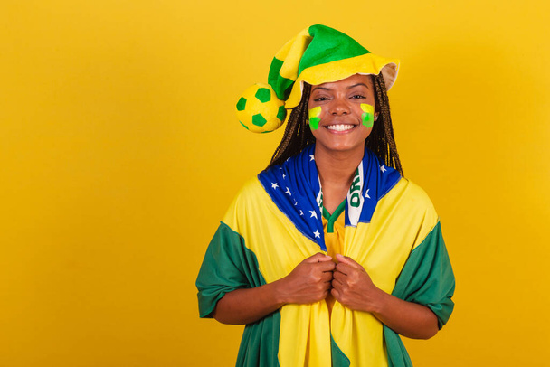 black woman young brazilian soccer fan. wearing hat and flag. Dressed for the game. - Foto, Imagen