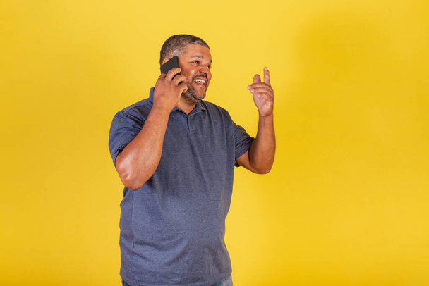 Brazilian black man, adult talking on cell phone, voice call. - Foto, afbeelding