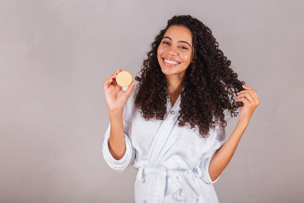 Brazilian black woman, wearing bathrobe and towel. vegan products for beauty and skin and hair care. soaps, Spa, self care. welfare. - Valokuva, kuva