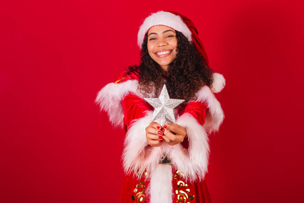 beautiful brazilian black woman, dressed as santa claus, christmas clothes. holding christmas star, decoration. - Fotoğraf, Görsel