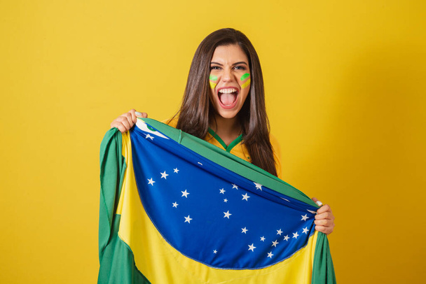 Woman supporter of Brazil, 2022 world cup, soccer championship, holding flag waving victory. - Foto, Imagem