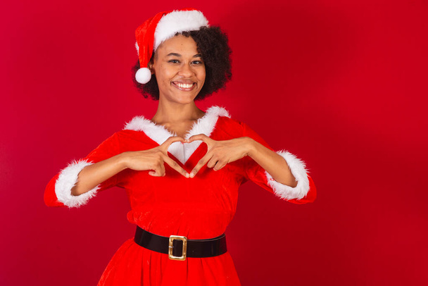 beautiful black brazilian woman, dressed as santa claus, mama claus, heart sign with hands - Foto, immagini