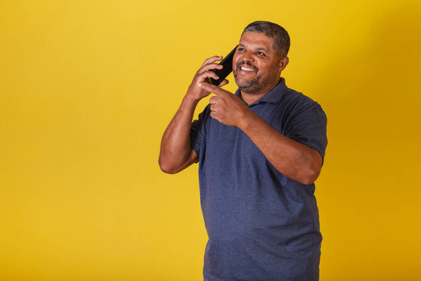 Brazilian black man, adult talking on cell phone, voice call. - Foto, afbeelding