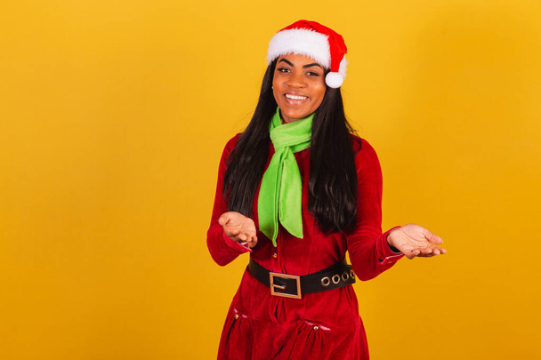 Beautiful black Brazilian woman, dressed in christmas clothes, santa claus, inviting with hands, come. - Photo, image
