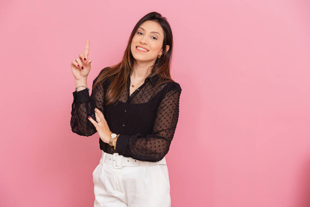 Beautiful Brazilian Caucasian Woman, Pink Background, with Raised Finger Suggesting Idea, Question and Suggestion, Entrepreneur. - Foto, immagini