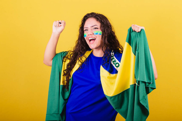 Soccer fan woman, brazil fan, world cup, holding flag and cheering, celebrating and partying, dancing. - Foto, Imagem