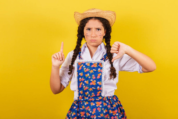 Girl wearing typical clothes for Festa Junina. thumb down, negative, disapproval. For the Arraia party - Zdjęcie, obraz