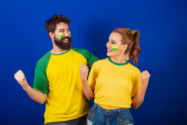 Caucasian couple, soccer fans from Brazil, celebrating and cheering - Zdjęcie, obraz