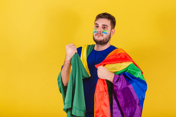 Brazilian caucasian man, soccer fan from Brazil, holding LGBT flag, gender equality concept, lgbt pride, confident. diversity. Sexuality. - Foto, immagini
