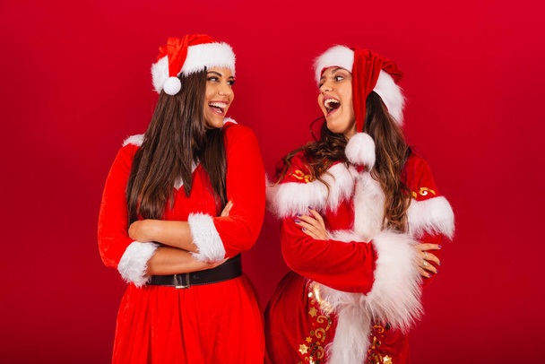 Brazilian female friends, dressed in Christmas clothes, Santa Claus. with arms crossed. - Fotoğraf, Görsel