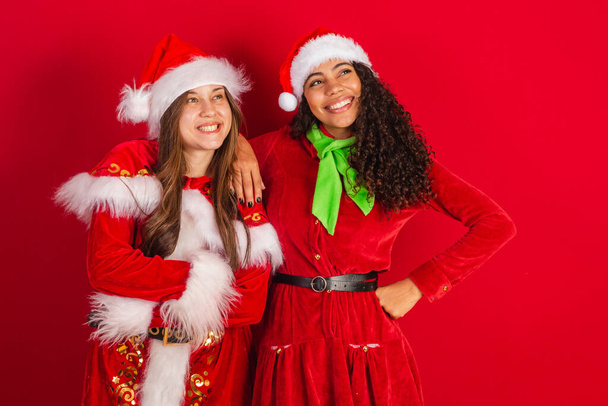 two brazilian female friends, dressed in christmas clothes, santa claus, - Zdjęcie, obraz