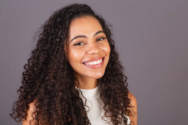 Young Brazilian black woman, close-up photo, smiling looking at camera, white teeth, smile. - Fotoğraf, Görsel