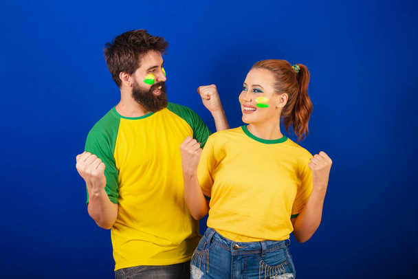 Caucasian couple, soccer fans from Brazil, celebrating and cheering - Фото, зображення