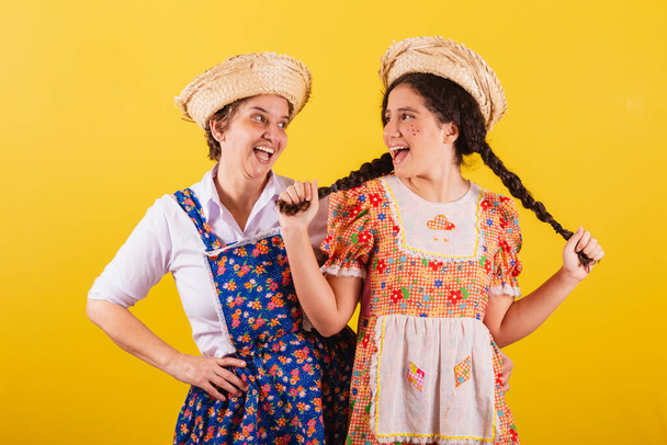 grandmother and granddaughter dressed in typical Festa Junina clothes. Smiling and posing for a photo. - Fotografie, Obrázek